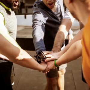 Group of people with hands in team pose